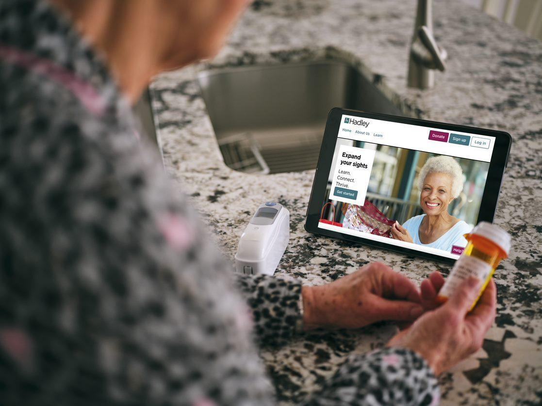 Older individual viewing HadleyHelps.org resources on a small tablet